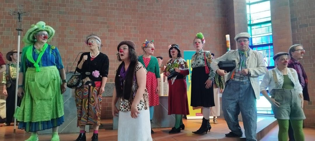 Clowns staunen ins Leere, in einem Kirchenraum